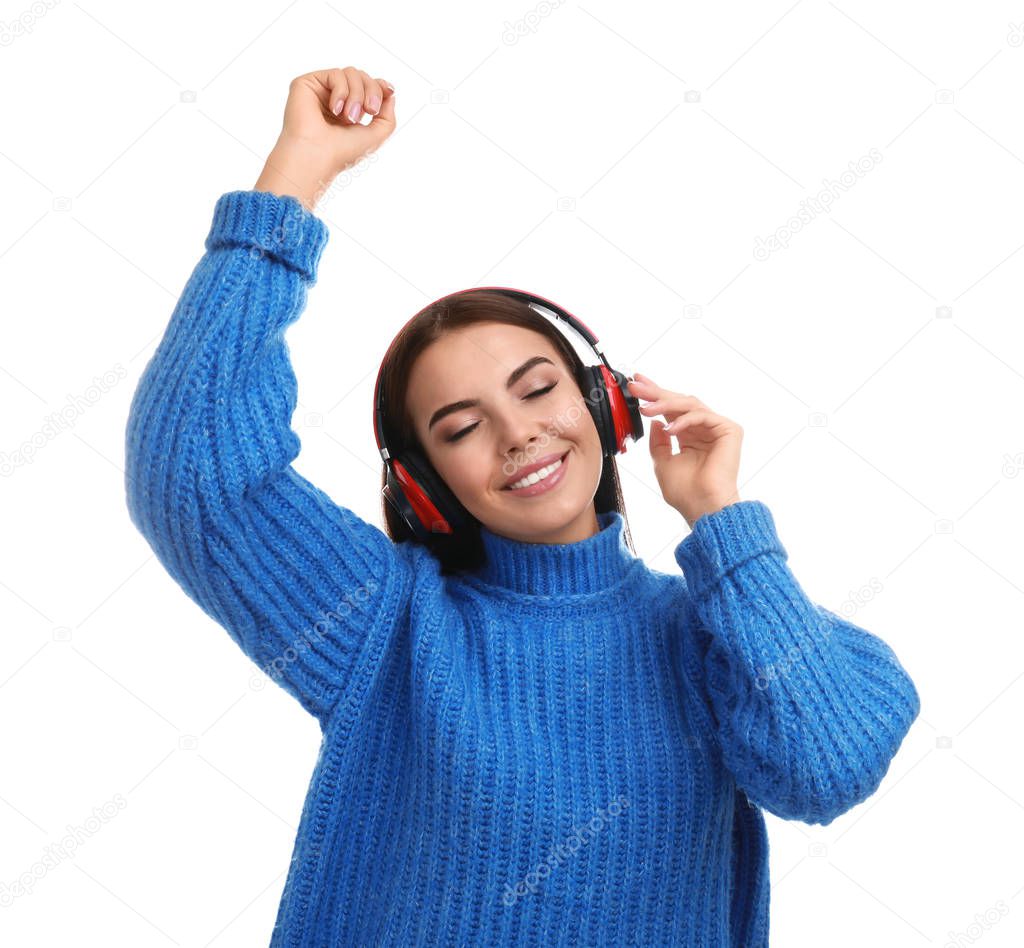 Young woman listening to music with headphones on white background