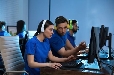 Gençler kapalı bilgisayarlarda video oyunları oynuyorlar. Esports turnuvası