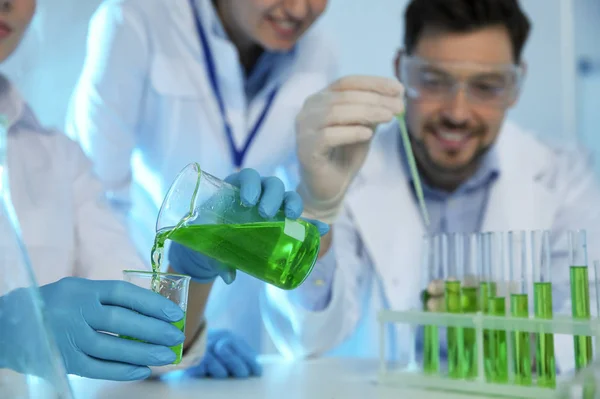 Grupo de científicos que trabajan con la muestra en el laboratorio de química, primer plano — Foto de Stock