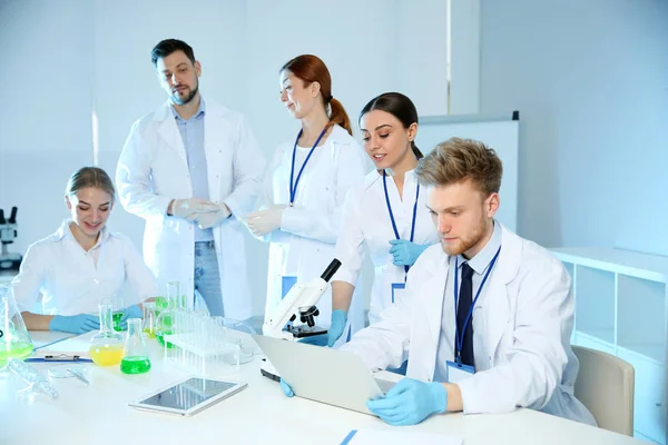 Группа ученых, работающих в современной химической лаборатории — стоковое фото