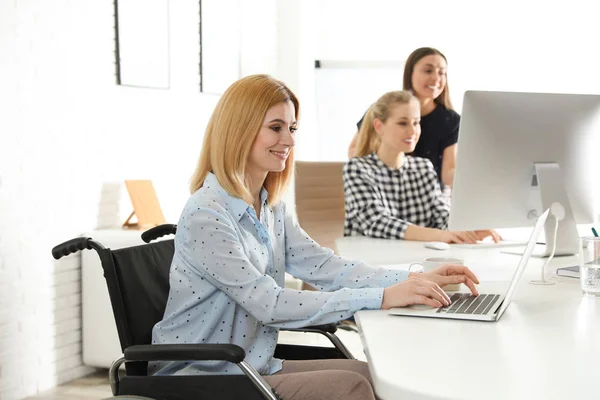 Retrato de la mujer en silla de ruedas con sus colegas en el lugar de trabajo — Foto de Stock