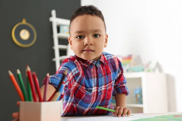 Söt liten afro-amerikanska barn ritning vid bordet i dagis. Inomhusaktivitet — Stockfoto