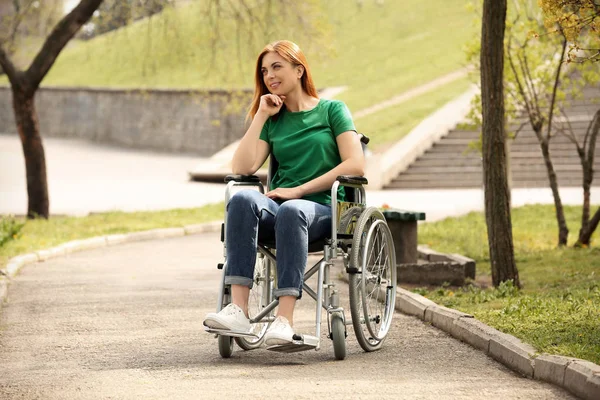 Jonge vrouw in rolstoel in Park op zonnige dag — Stockfoto