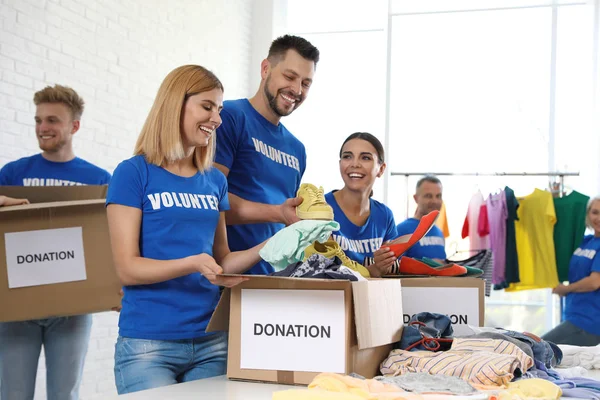 Equipo de voluntarios recogiendo donaciones en cajas interiores — Foto de Stock