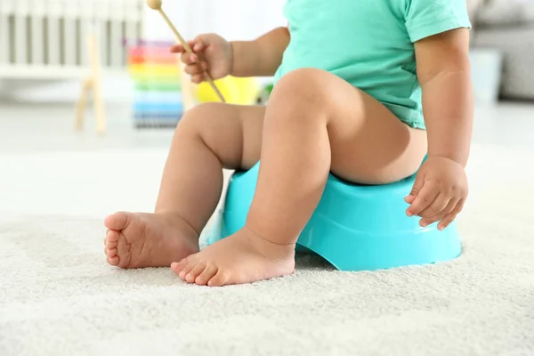 Menino com pau de madeira sentado no penico em casa, close-up — Fotografia de Stock