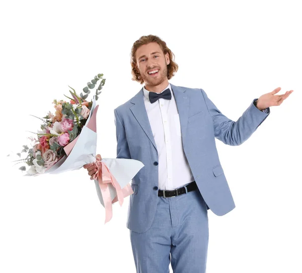 Joven hombre guapo en traje elegante con hermoso ramo de flores sobre fondo blanco — Foto de Stock