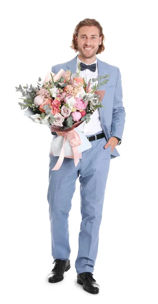 Jovem homem bonito em terno elegante com lindo buquê de flores no fundo branco — Fotografia de Stock