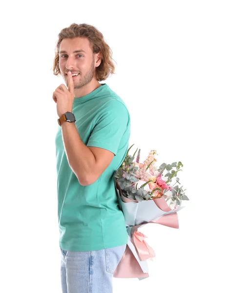 Молодой красивый мужчина прячет красивый букет цветов за спиной на белом фоне — стоковое фото