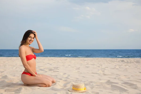 Сексуальна молода жінка в стильному бікіні відпочиває на пляжі. Простір для тексту — стокове фото