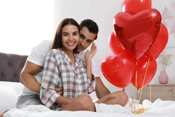 Όμορφο ζευγάρι με τα μπαλόνια σε σχήμα καρδιάς στο υπνοδωμάτιο — Φωτογραφία Αρχείου
