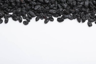 Birçok kuru üzüm ve beyaz arka plan, üst görünüm metin için alan. Sağlıklı atıştırmalık olarak kurutulmuş meyve