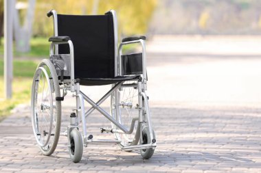 Güneşli günde şehir parkında boş tekerlekli sandalye