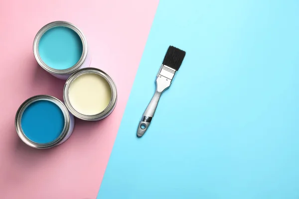 Abrir latas de pintura, pincel y espacio para texto sobre fondo de color, vista superior — Foto de Stock