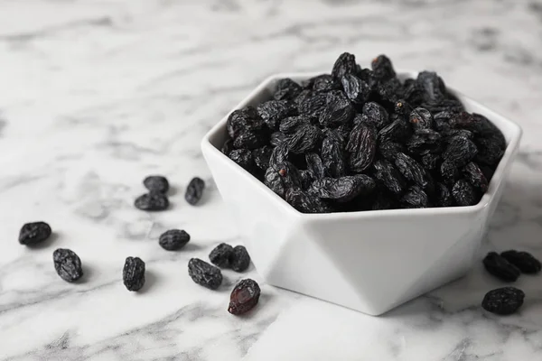 Tigela com passas na mesa de mármore. Fruta seca como lanche saudável — Fotografia de Stock