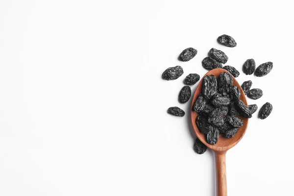 Cuillère avec raisins secs et espace pour le texte sur fond blanc, vue du dessus. Fruits secs comme collation saine — Photo