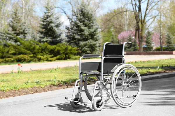 Pusty wózek inwalidzki w parku miejskim w słoneczny dzień — Zdjęcie stockowe