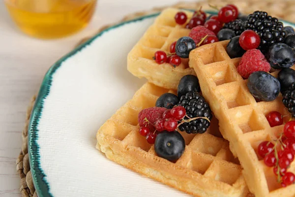 Delicious waffles with fresh berries served on white wooden table, closeup — Stock Photo, Image