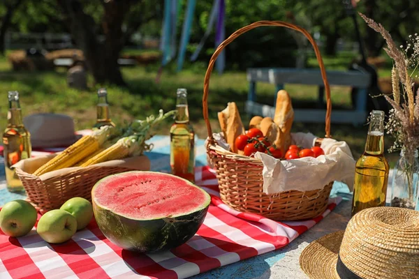 Diferentes productos para picnic de verano servido en manta a cuadros al aire libre — Foto de Stock