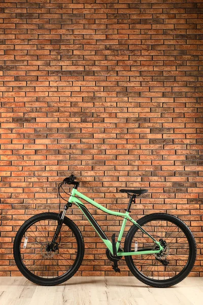 Vélo moderne près du mur de briques à l'intérieur. Espace pour le texte — Photo