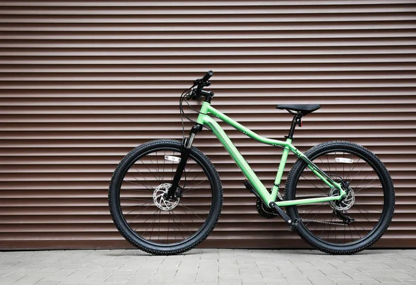 Neue moderne Farbe Fahrrad in der Nähe braune Wand im Freien — Stockfoto