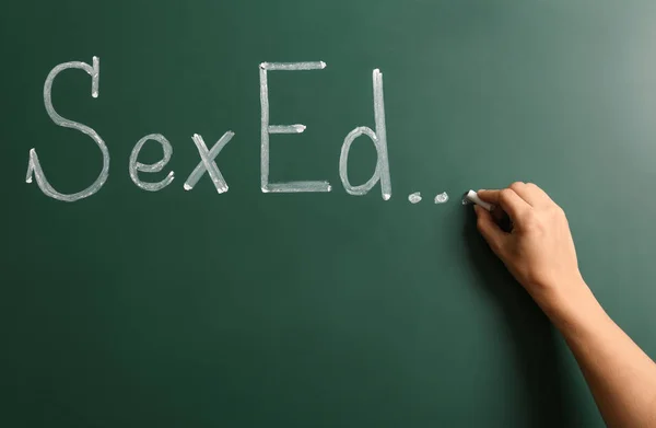 Mujer escribiendo texto "SEXO ED"... en pizarra verde — Foto de Stock