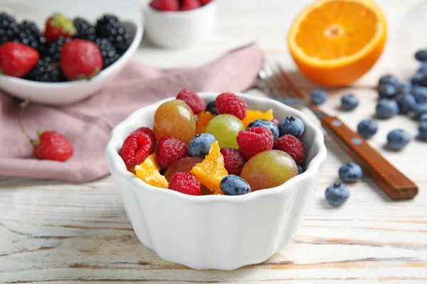 Verse smakelijke fruitsalade op witte houten tafel — Stockfoto