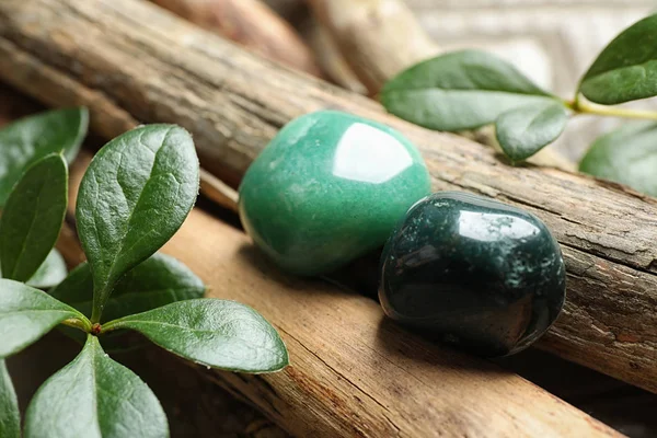 Hermosas piedras preciosas verdes aventurina y heliotropo con palos de madera —  Fotos de Stock