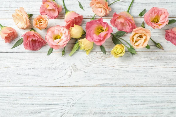 Flat lay composition with beautiful Eustoma flowers on white wooden table, space for text — Stock Photo, Image