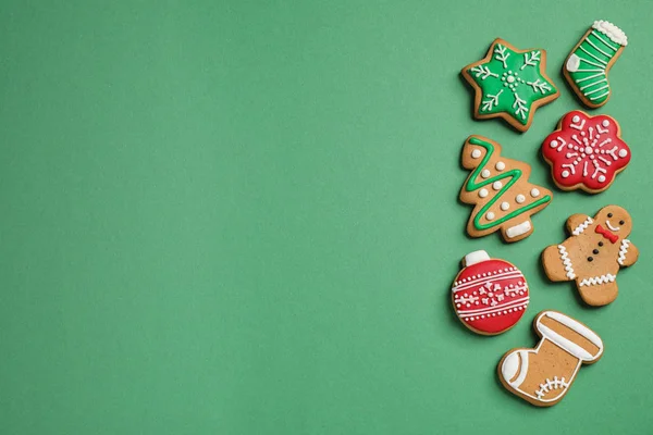 Platte lay compositie met lekkere zelfgemaakte kerstkoekjes op groene achtergrond, ruimte voor tekst — Stockfoto