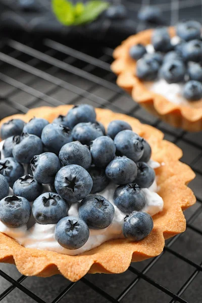 Patiserie dulce delicioasă cu fructe de pădure pe rack de răcire, closeup — Fotografie, imagine de stoc