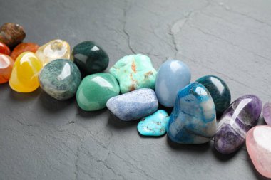 Row of different beautiful gemstones on grey background clipart