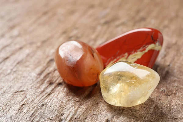 Beautiful red and white jade, carnelian agate and citrine quartz gemstones on textured surface