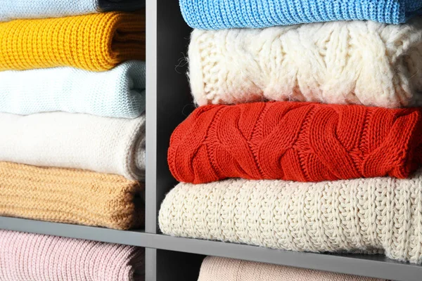 Muchas prendas de punto de invierno apiladas en los estantes, primer plano — Foto de Stock