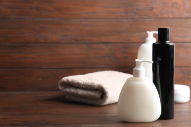 Ahşap masa üzerinde banyo malzemeleri ve katlanmış havlu, metin için alan