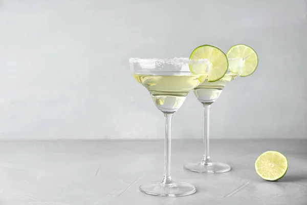 Glas citron droppe martini cocktail med lime skiva på ljusbord mot grå bakgrund. Utrymme för text — Stockfoto