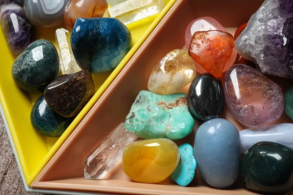 Bandeja de plástico con diferentes piedras preciosas hermosas en la mesa — Foto de Stock