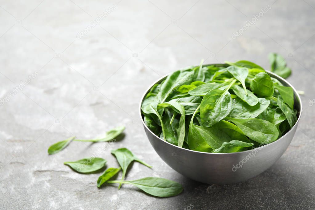 Fresh green healthy spinach on grey table. Space for text
