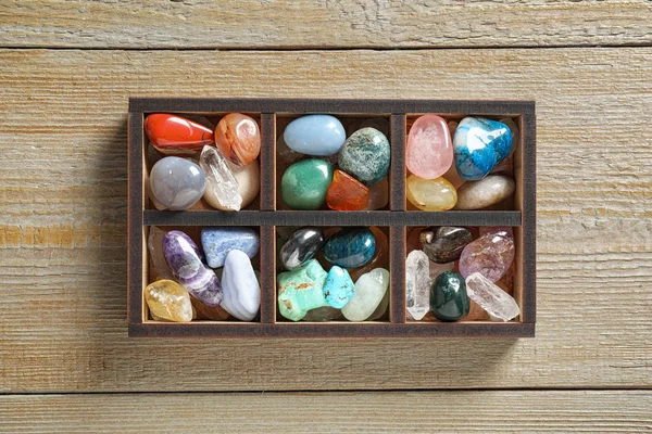Doos met verschillende mooie edelstenen op houten tafel, platte lay — Stockfoto