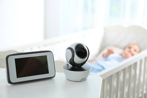 Babyphone und Kamera auf dem Tisch in der Nähe des Kinderbettes mit Kind im Zimmer. Video-Kindermädchen — Stockfoto