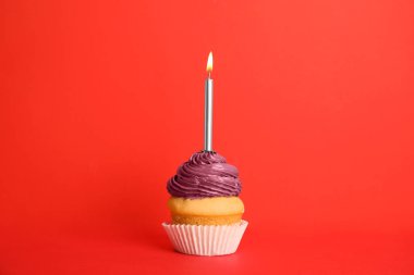Kırmızı arka plan üzerinde mum ile Doğum günü cupcake