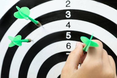 Dart tahtası yakınında yeşil oklu kadın, closeup