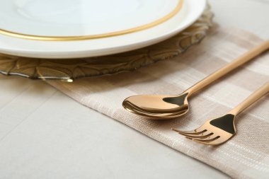 Gri arka plan üzerinde altın çatal bıçak takımı ile güzel masa ayarı