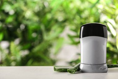 Bulanık arka plan karşı beyaz ahşap masa üzerinde Deodorant konteyner ve aloe vera. Metin için alan