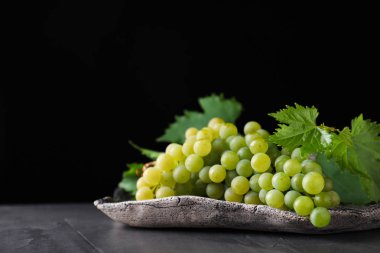 Siyah arka plan karşı gri masada taze olgun sulu üzüm