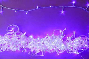 Mor arka planda parlayan Noel ışıkları, üst görünüm