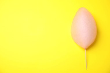 Sarı arka plan üzerinde tatlı pembe pamuk şeker, üst görünümü. Metin için alan