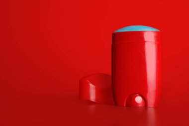 Kırmızı arka plan karşı masada sopa deodorant. Tasarım alanı