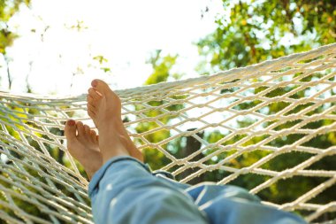 Yeşil bahçede rahat hamakta dinlenen genç kadın, yakın çekim