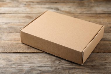 Ahşap masa üzerinde bir kapalı karton kutu