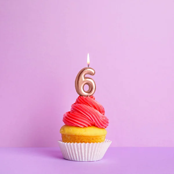Cupcake d'anniversaire avec numéro six bougie sur fond violet — Photo
